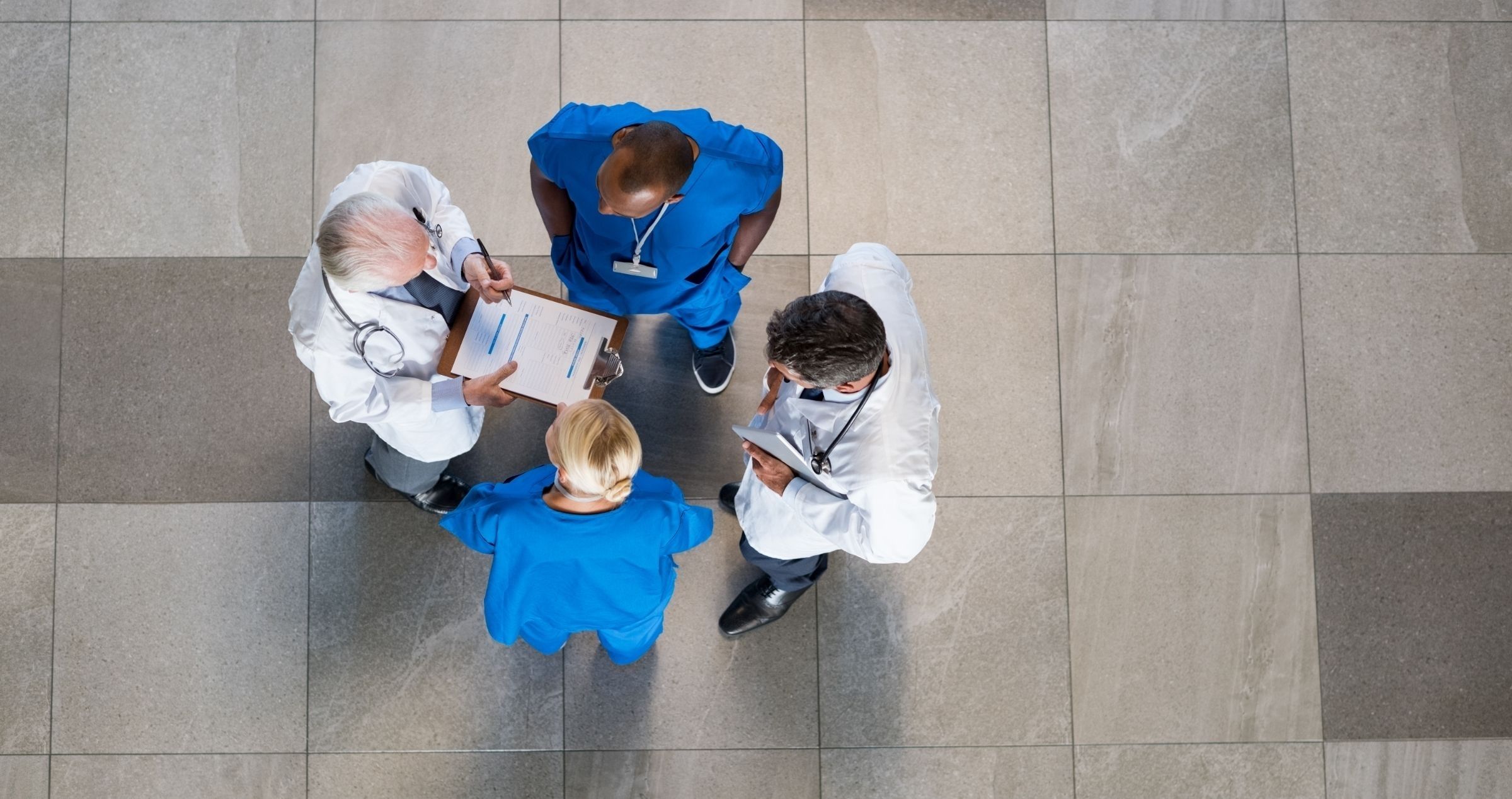 Overhead shot of group of doctors meeting in hallway having a discussion